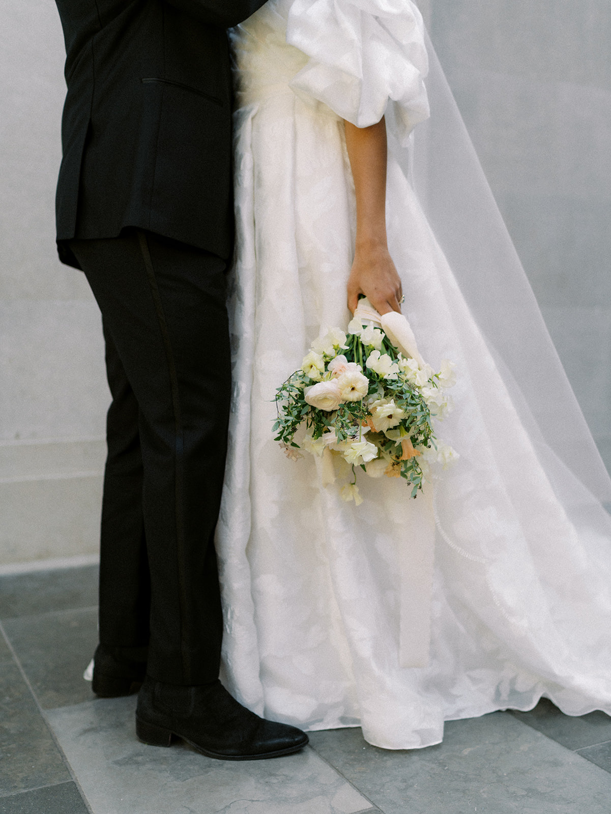 Wedding portrait of couple while bride holds bouquet